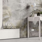 Tapet personalizat leaf cu frunze de palmier si alte plante exotice in tonuri de bej si gri pe un fundal cu aspect de stucada pentru un stil rustic modern gold concrete leaves