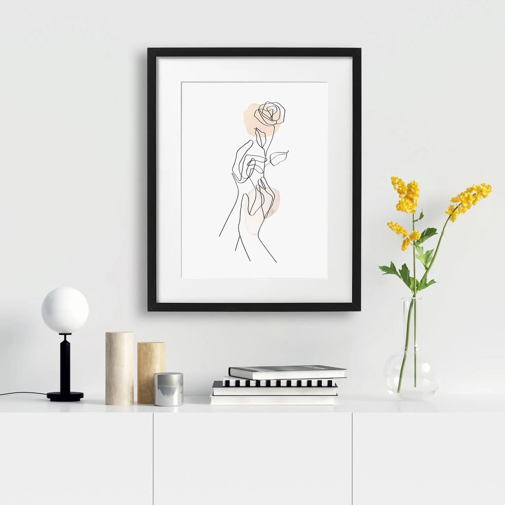 Tabloul cu rama care ilustreaza un desen line art simplu si elegant cu 2 maini tinand un trandafir gentle gesture